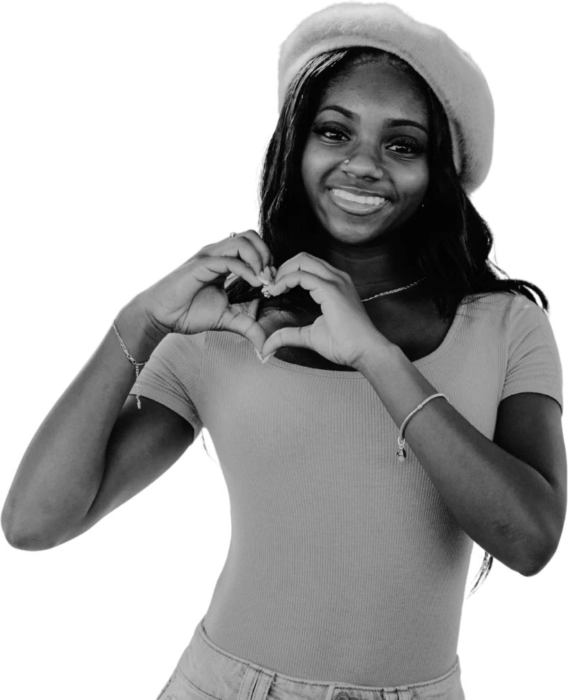 A young person making a heart with her hands