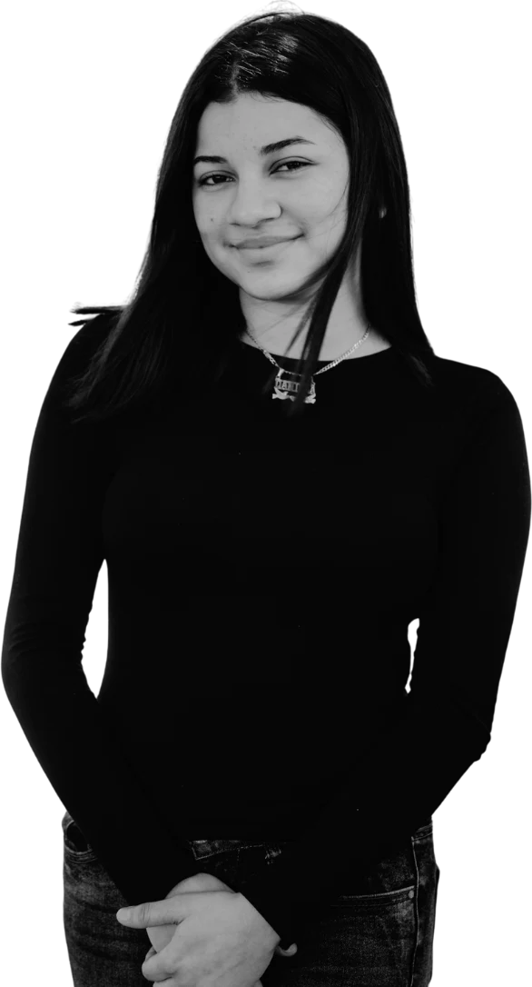 A young person smiling with her hands folded