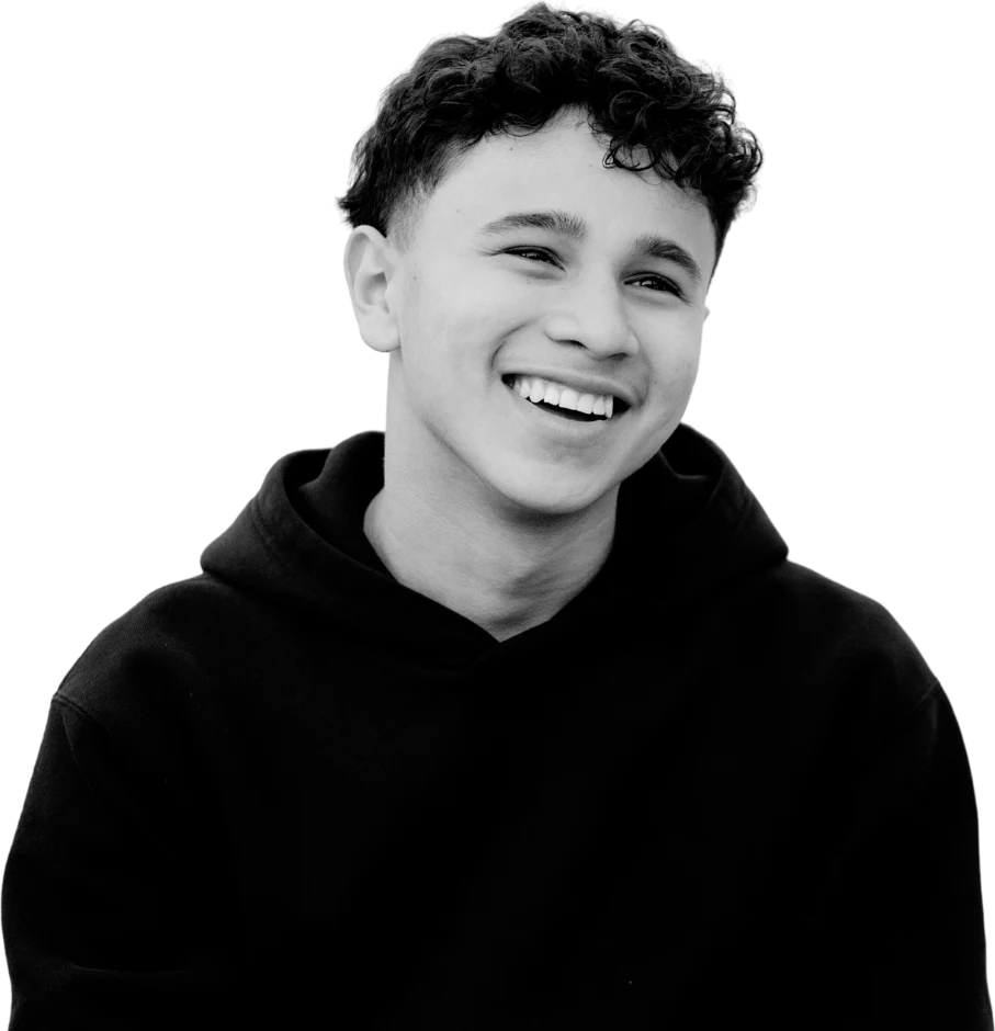A young person smiling in a hoodie