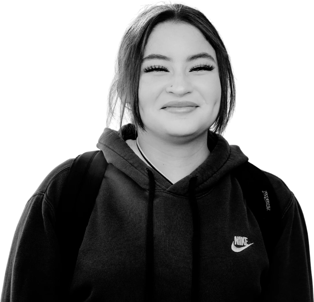 A young person smiling with a backpack
